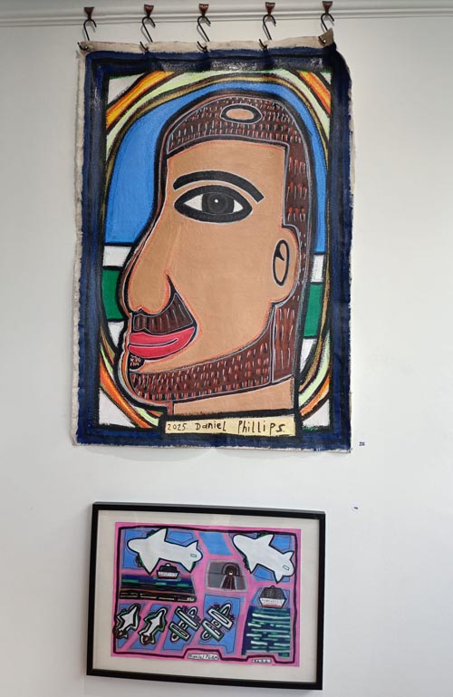 “Self-Portrait – Seat F plane to Auckland 2025” on a wall abover a smaller work by Daniel Phillips.